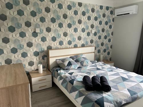 Schlafzimmer mit einem Bett mit geometrischer Tapete in der Unterkunft Maison au calme avec rivière à côté de CHARTRES 