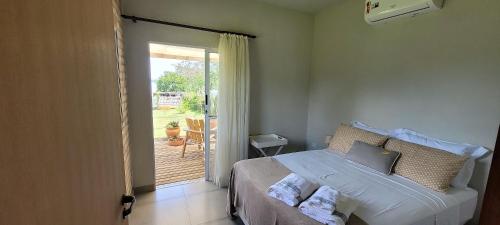 a bedroom with a bed and a door to a patio at Casinha na Represa 3 in CÃ¡ssia