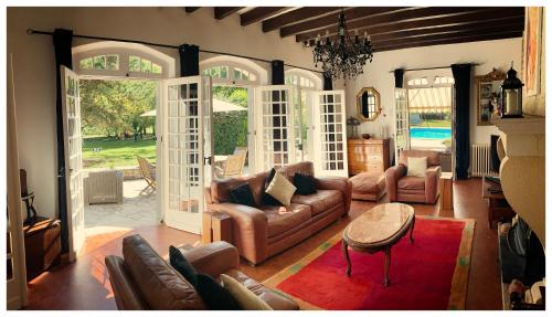 un salon avec des canapés et un lustre dans l'établissement Le Petit Comte Bergerac an Oasis of Calm, à Bergerac