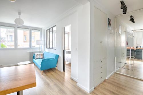 un appartement blanc avec une chaise bleue dans une pièce dans l'établissement Appartement Vilcenia - Welkeys, à Vincennes