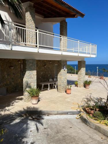 a patio of a house with a balcony and the ocean at Suite Panoramic in Porticello