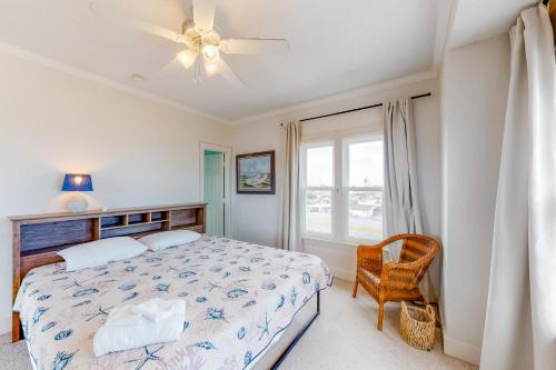 a bedroom with a bed with a ceiling fan and a window at Carried Away #16-IC in Avon