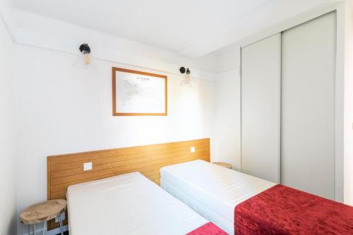 a bedroom with two beds and a picture on the wall at Résidence Plagne Lauze - maeva Home - Appartement 2 Pièces 4 Personnes - Sélection MAE-0864 in Mâcot La Plagne