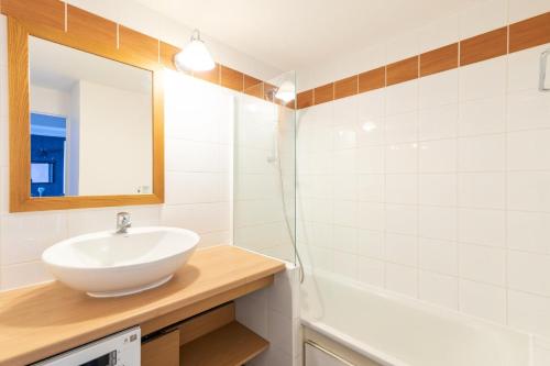 a bathroom with a sink and a mirror and a tub at Résidence Plagne Lauze - maeva Home - Appartement 2 Pièces 4 Personnes - Séle 64 in Mâcot La Plagne