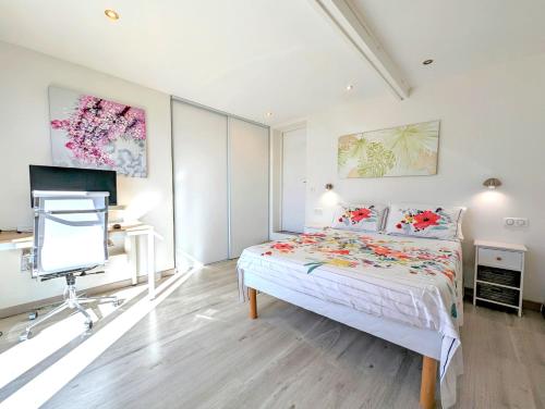 um quarto com uma cama, uma secretária e uma televisão em The Villa Capitou em Fréjus
