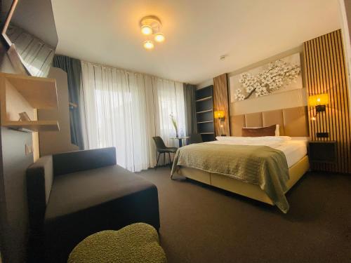 a hotel room with a bed and a chair at Apartments Amtzell, kontaktloser Check-in in Amtzell