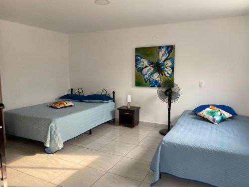 a room with two beds and a fan at Apartamento Súper acogedor Envigado Terraza 401 in Envigado