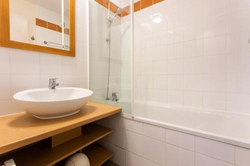 uma casa de banho com um lavatório e uma banheira em Résidence Plagne Lauze - maeva Home - Appartement 3 Pièces 7 Personnes - Séle 14 em Mâcot La Plagne