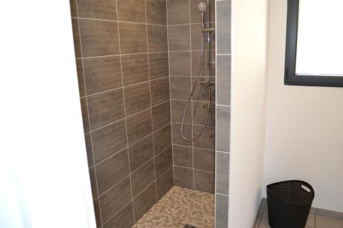 une salle de bain avec une douche avec une porte vitrée dans l'établissement Gite avec piscine privée et climatisation à Cahors, à Cahors