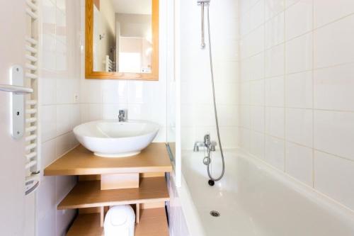 uma casa de banho com um lavatório e uma banheira em Résidence Plagne Lauze - maeva Home - Appartement 2 Pièces 5 Personnes - Séle 74 em Mâcot La Plagne