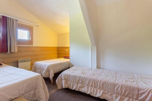 une chambre d'hôtel avec deux lits et une fenêtre dans l'établissement Résidence Plagne Lauze - maeva Home - Appartement 3 Pièces 7 Personnes - Sélection MAE-4404, à Mâcot La Plagne
