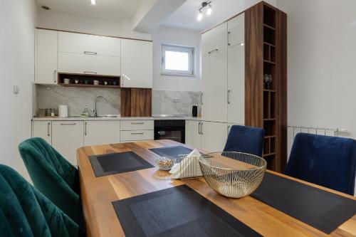 a kitchen with a wooden table and blue chairs at Apartman Square Trg Prijedor in Prijedor