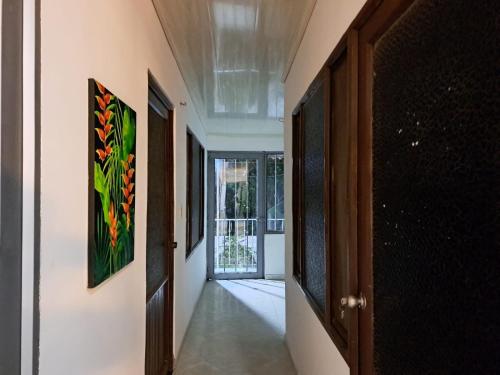 a hallway with a door and paintings on the wall at Casa La Ceiba in San José del Guaviare