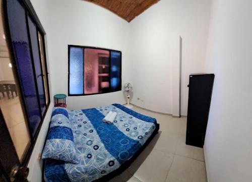 ein Schlafzimmer mit einem blauen Bett in einem Zimmer in der Unterkunft Casa La Ceiba in San José del Guaviare
