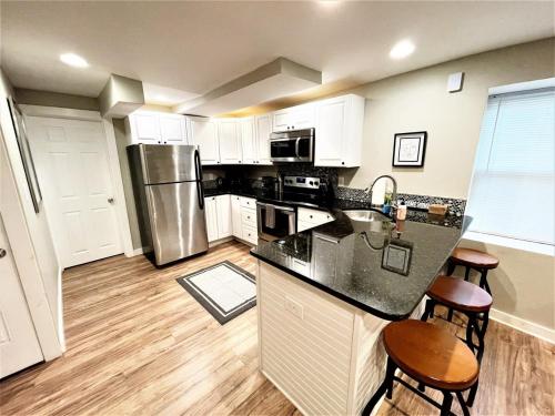 een keuken met witte kasten en een zwart aanrecht bij Boardwalk- large modern unit with King bed fast WIFI free coffee and easy parking in Wilmington