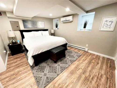 een slaapkamer met een groot bed en een houten vloer bij Boardwalk- large modern unit with King bed fast WIFI free coffee and easy parking in Wilmington