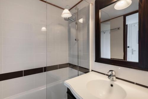une salle de bain avec un lavabo, un miroir et une douche dans l'établissement Résidence Port du Crouesty - maeva Home - Appartement 2 Pièces 4 Personnes - Confort MAE-6444, à Arzon