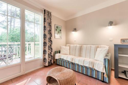 un salon avec un canapé et une fenêtre dans l'établissement Résidence Lacanau Les Pins - maeva Home - Appartement 2 Pièces 4 Personnes - Sélection MAE-6514, à Lacanau