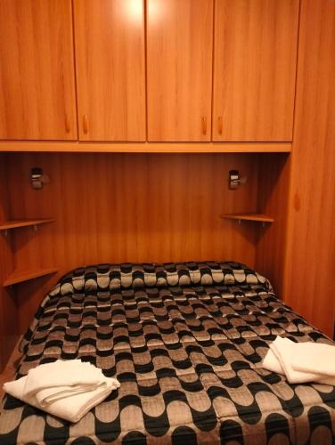 a bed in a room with wooden walls and cabinets at La Bomboniera Cascia in Cascia