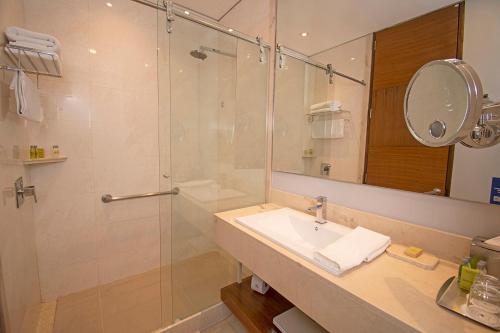 a bathroom with a shower and a sink and a mirror at DoubleTree by Hilton Bogota Parque 93 in Bogotá