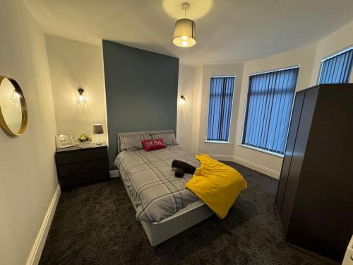 a bedroom with a bed with a yellow blanket at Brand new refurb 8 person house in Hull