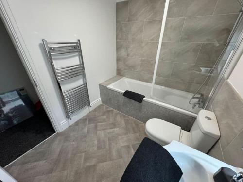 a bathroom with a shower and a toilet and a tub at Brand new refurb 8 person house in Hull
