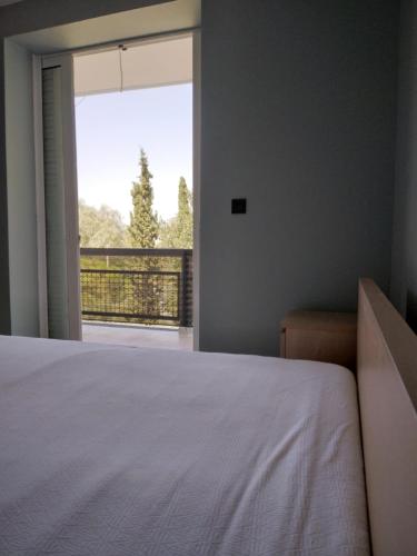 um quarto com uma cama e uma grande janela em Down town house with uni sence! em Atenas