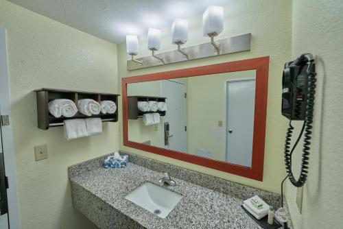 a bathroom with a sink and a mirror at The Mariner Resort Cape Cod by The Red Collection in West Yarmouth
