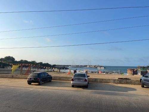 dos coches estacionados al lado de una carretera junto a la playa en Hotel brisas del mar 2022, en Catia La Mar