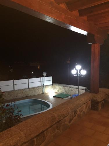 a jacuzzi tub on a patio at night at Valdebruna ll y de Gredos in Navaluenga