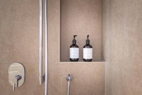 two bottles of wine sitting on a shelf in a bathroom at Hotel Maier in Friedrichshafen