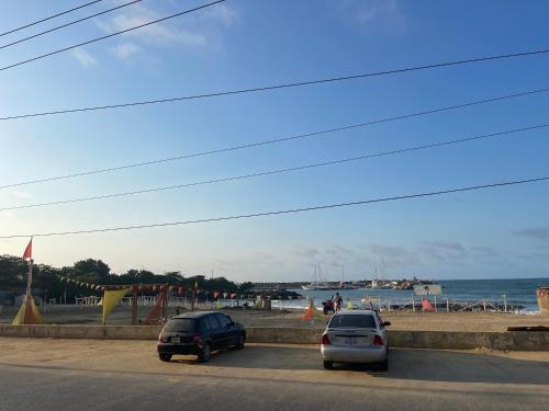 two cars parked on the side of a road near the beach at Hotel brisas del mar 2022 in Catia La Mar