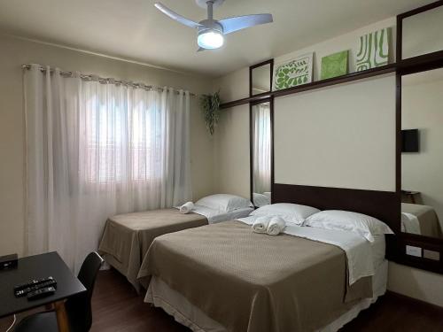 a hotel room with two beds and a window at Recanto Amana · Casa inteira · Centro em São João da Boa Vista in São João da Boa Vista