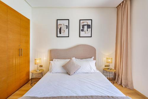 - une chambre avec un grand lit blanc et 2 tables dans l'établissement luxueux & spacieux appartement a prestigia, à Marrakech