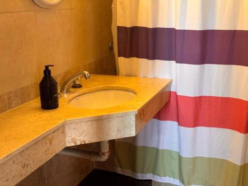 a bathroom with a sink and a colorful shower curtain at Departamento completo en barrio sur! in San Miguel de Tucumán