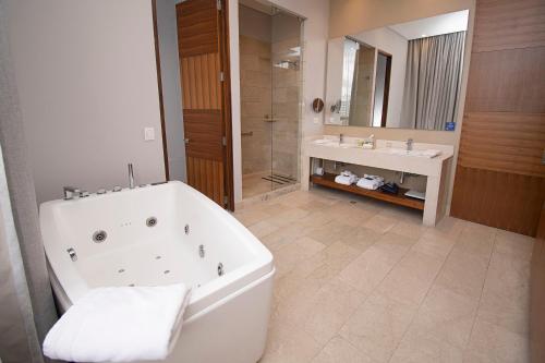 ein Badezimmer mit einer Badewanne, einem Waschbecken und einer Badewanne in der Unterkunft DoubleTree by Hilton Bogota Parque 93 in Bogotá