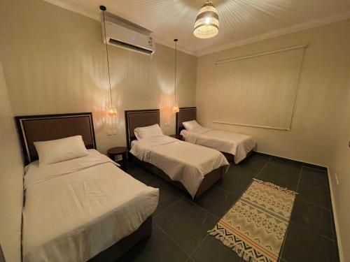 um quarto de hotel com duas camas e um tapete em fun beach durrat alarous -فن بيتش درة العروس em Durat Alarous