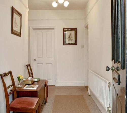a hallway with a desk and a door with a table and chairs at Beech Tree Cottage with free parking in Bury Saint Edmunds