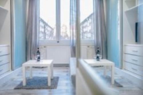 a bathroom with two white tables and a window at MODRÝ APARTMÁN, Račianska 29, BRATISLAVA in Bratislava