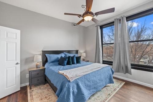 Un dormitorio con una cama azul y una ventana en Modern Condo Inside The Historic St Regis, en Grand Junction