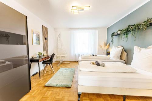 two beds in a room with a desk and a bedroom at Große Terassen-Wohnung mit Grill, Playstation 5, Billardtisch und Massagesessel in Haan