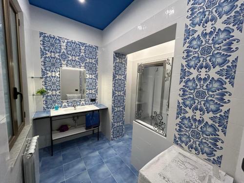 un bagno con piastrelle bianche e blu sulle pareti di Appartamento con Terrazzo a Mariglianella