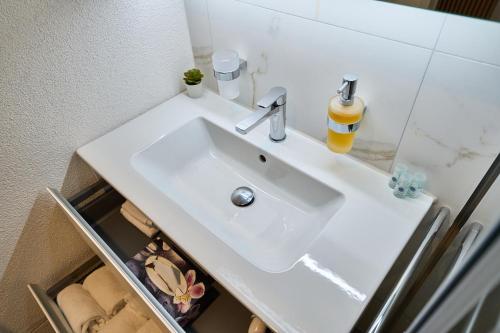 a bathroom with a white sink and a mirror at Cartea Apartments Zürich Airport in Opfikon