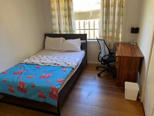 a small bedroom with a bed and a desk and a desk at 12 Olive Cozy Rooms in Frankston