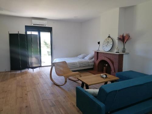 uma sala de estar com uma cama e uma lareira em Maison loft dans ancienne ferme em Montauban