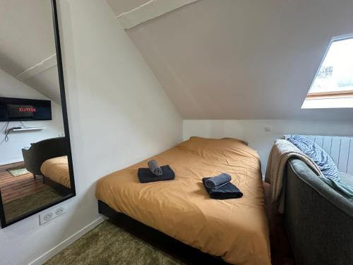 um pequeno quarto com uma cama com dois sapatos em IMMEUBLE ST-PIERRE - GARE 10min - HORTILLONNAGES 5min - WIFI - TV HD em Amiens
