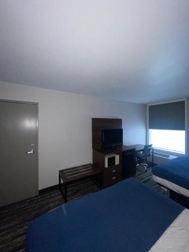 Habitación de hotel con cama y escritorio con TV. en Quality Inn, en Dillard