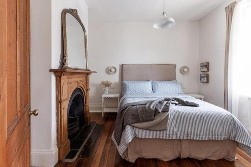 um quarto com uma cama e uma lareira em Galvin Town Cottage, convenient to CBD em Kings Park