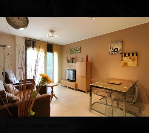 a living room with a table and a kitchen at Apartament Calella in Calella