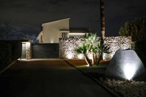 uma casa iluminada à noite com uma pedra em Villa Vetrano em Cimitile